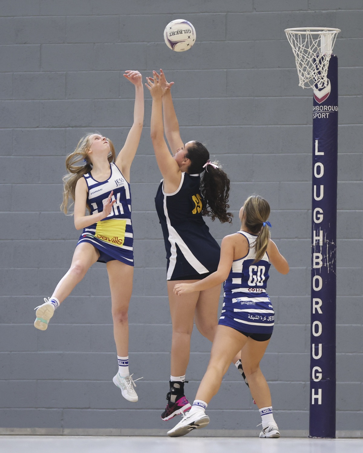 Two players leap and stretch for the ball